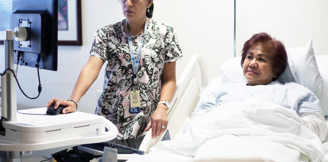 nurse reviewing test results with a patient in bed