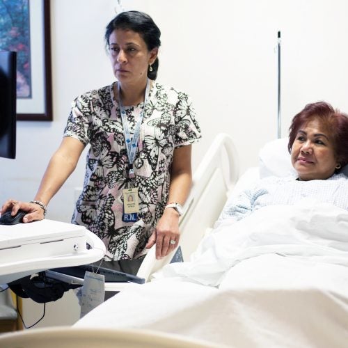 a nurse looks at a diagnostic image with a patient