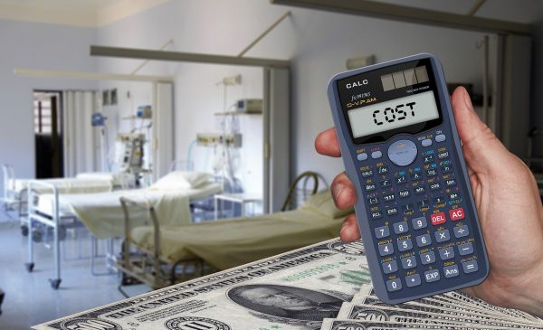 calculator and stacks of money with hospital room in background