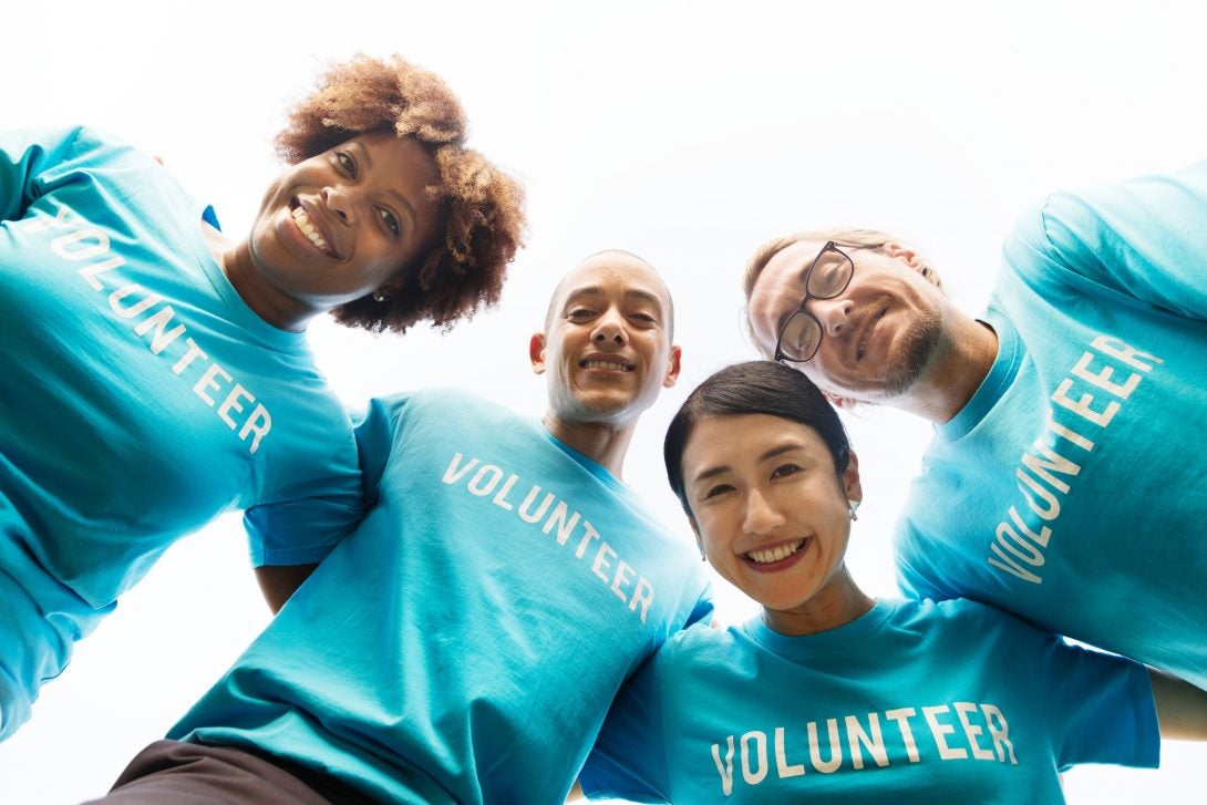 a diverse group of volunteers smile down at the camera