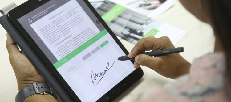 woman signing an electronic consent on a tablet