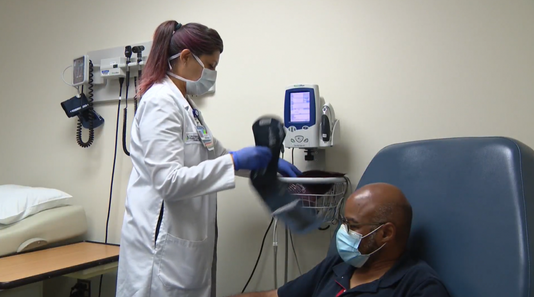 a CRC nurse takes the blood pressure of a Moderna trial volunteer