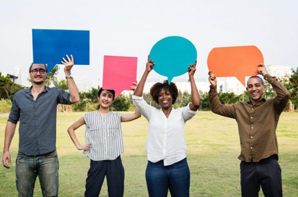 diverse people holding up multicolored speech bubbles