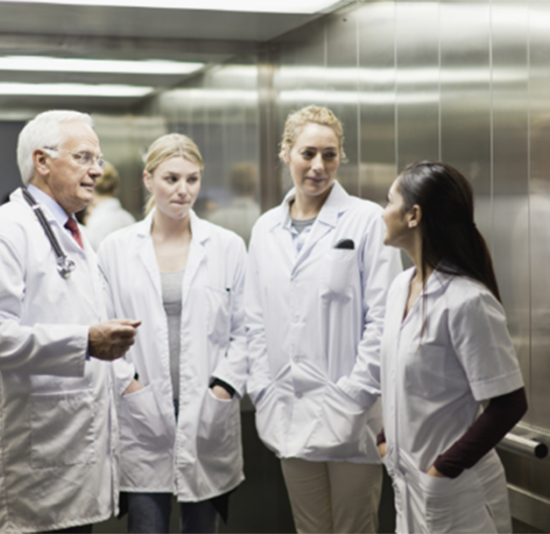 a group of health care workers talking in an elevator