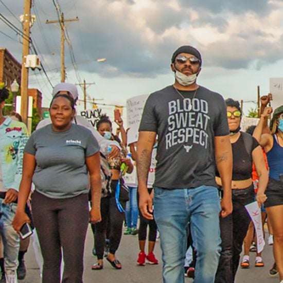 a group of protesters march in the street. photo courtesy of UIC School of Public Health.