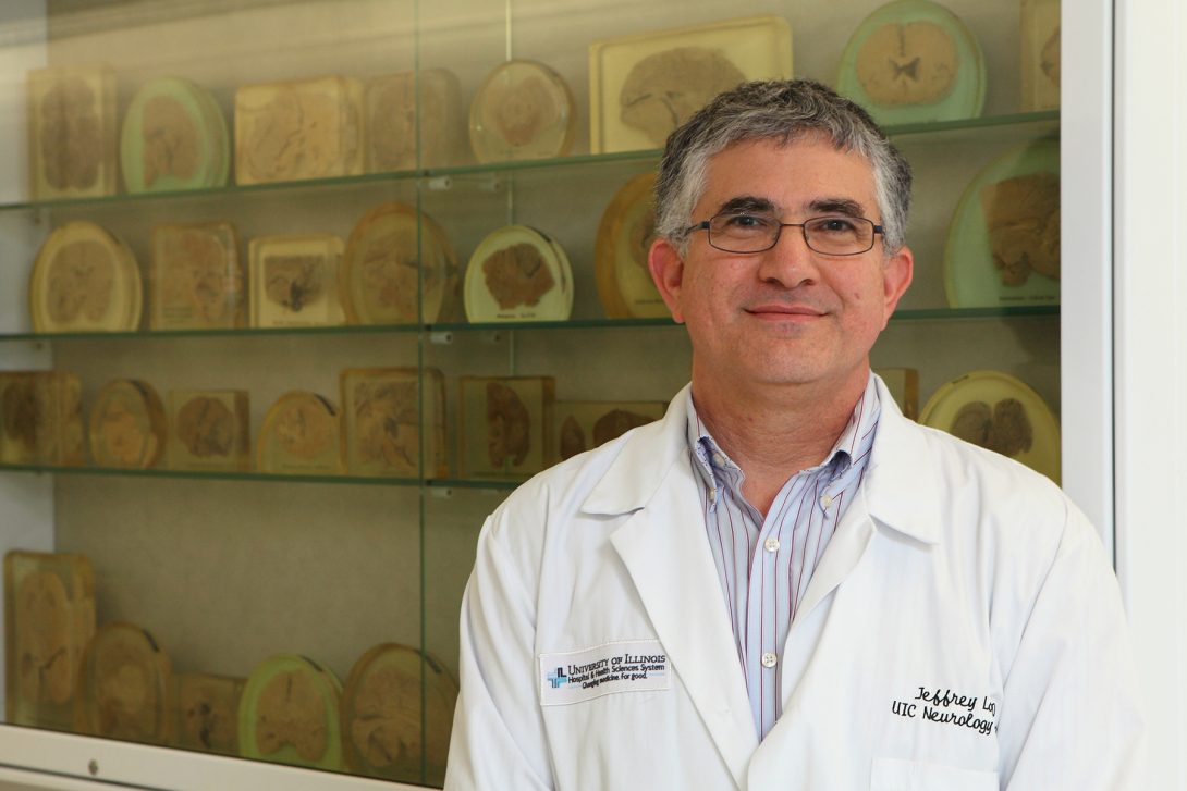 Doctor Jeffrey Loeb in front of case displaying human brain tissue samples. Photo: Jenny Fontaine
