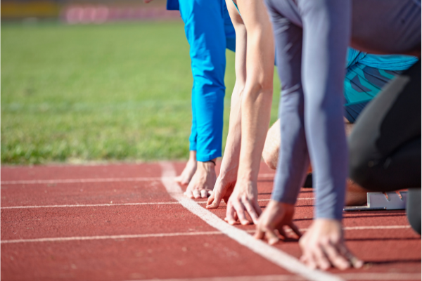 people crouched at starting line of a track