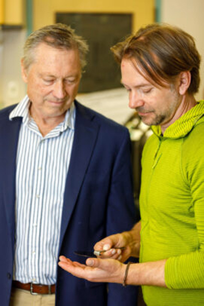 Inventor of the Year award recipients Michael Caffrey (left) and Igor Paprotny examine a component of their device for detecting airborne virus particles.