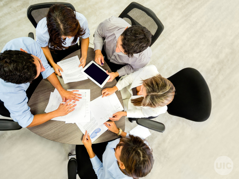 a group of people work around a table