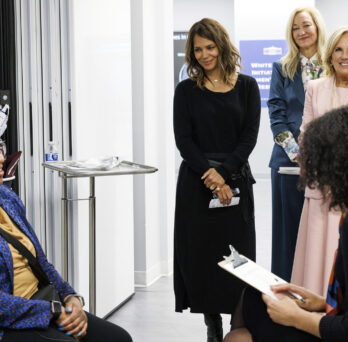 Maki looks on as a research participant demonstrates wearable menopause technology to First Lady Dr. Jill Biden and actress Halle Berry
                  
