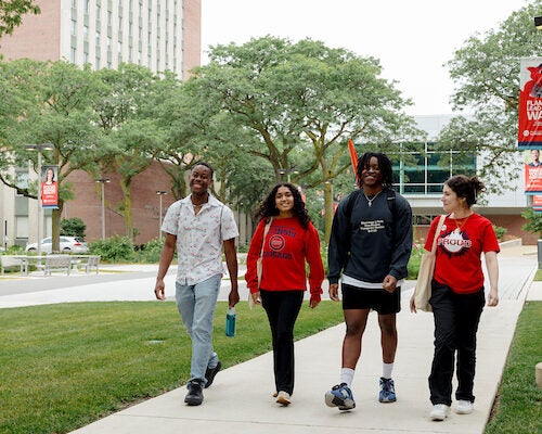 Group of UIC students walking on campus smiling