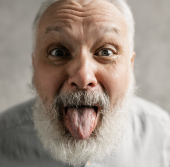 An older man sticks out his tongue with a silly expression 