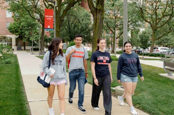 four students walking and smiling